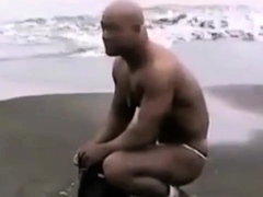 Asian bodybuilder barely covered at the beach